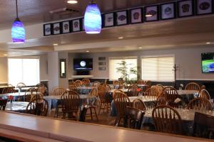 un comedor con mesas, sillas y luces en O'Cairns Inn and Suites en Lompoc