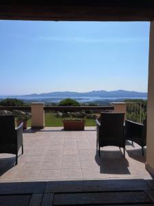 un patio con sillas y vistas al océano en Villa Sprafundu en La Maddalena