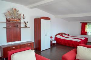 a bedroom with a bed and a red couch at Hotel Romantika in Varna City