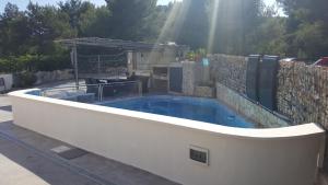 uma piscina num quintal com uma parede de pedra em Apartment Kale em Šibenik