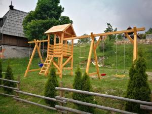 a playground with a wooden swing set in a yard at Lodge Nagramak in Sekulić 