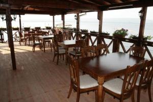 a group of tables and chairs on a patio with the ocean at Hotel Romantika in Varna City