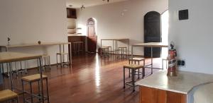 une pièce vide avec des tables et des tabourets dans un bâtiment dans l'établissement Vhostel, à Uberlândia