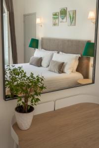 a white bed sitting in a room next to a window at Hotel Edouard VII in Biarritz