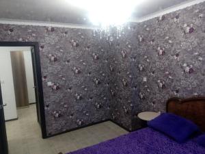 ノヴォクズネツクにあるКутузова 43 2 подъездの花の壁が紫色のベッドルーム1室