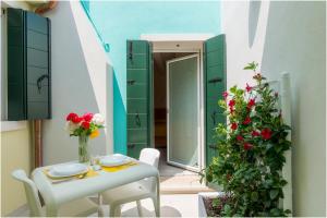 a table and chairs on a balcony with flowers at Tiffany Home in Burano