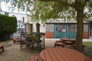 a picnic table with a grill next to a tree at Caulfields Hotel in Burry Port