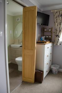 カーディガンにあるGwynfroのバスルーム(トイレ、シンク付)、木製のドアが備わります。