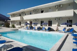 una piscina de hotel con sillas y sombrillas en Laganas Dreams 2 en Laganas