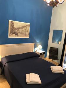 a blue bedroom with a bed with two towels on it at Casa Cristina in Maiori