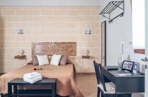 - une chambre avec un lit, une table et un bureau dans l'établissement La Creta b&b, à Mandurie