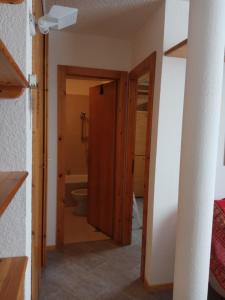 a bathroom with a toilet and a door to a tub at Bilocale Fronte Piste - Appartamentiflarida Sansicario Alto in San Sicario