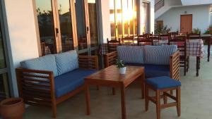 una cafetería con sillas azules y una mesa y sillas de madera en Neon Hotel, en Stalida