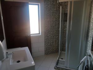 baño con lavabo, ducha y ventana en Almancil Hostel, en Almancil 35 fotos más