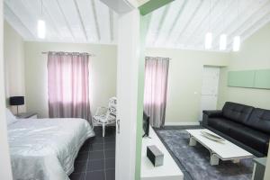 Casa Céu D'Abraão في Piedade: غرفة نوم بسرير واريكة وطاولة