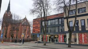 un bâtiment situé dans une rue en face d'une église dans l'établissement Central Apartment, à Palanga