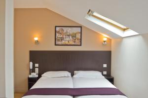een slaapkamer met een groot bed en een schilderij aan de muur bij Hôtel du Quai de Seine in Parijs