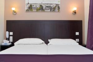 two beds in a hotel room with white sheets at Hôtel du Quai de Seine in Paris