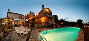 a house with a swimming pool in front of a house at Tsivaras Villas in Tsivarás