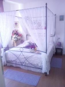 a bedroom with a canopy bed with white sheets at Ba.Lù. in Guspini