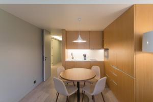 a kitchen and dining room with a table and chairs at Bessa Apartments - Growhome in Porto