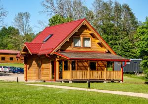 eine große Holzhütte mit rotem Dach in der Unterkunft "Pakalas" Villa&Resort in Šiškiniai
