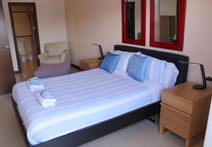 a bedroom with a bed with blue pillows and a chair at Dream Cuesta in Santa Cruz de Tenerife
