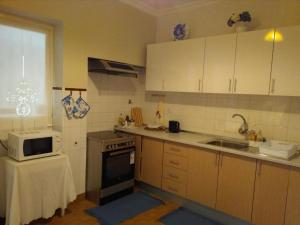 a small kitchen with a microwave and a sink at Lagoa´s House in Lagoa