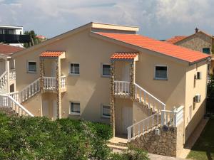 dom z 2 balkonami i pomarańczowym dachem w obiekcie Apartments Villa Engeli w mieście Vir