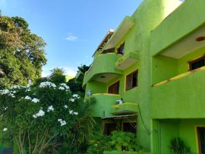 un edificio verde con árboles delante de él en Bamboo Flat, en Natal