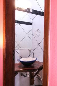 a bathroom with a bowl sink on a wooden table at Pousada do Vovô in Fronteira