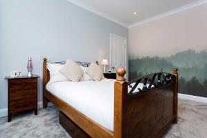 ロンドンにあるVeeve - Bespoke Wimbledon Retreatのベッドルーム1室(木枠の大型ベッド1台付)
