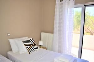 a bedroom with a bed and a window with a balcony at The Well in Chorafakia