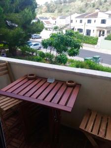 a balcony with a wooden bench and a view of a street at Atlantic Bay in Costa da Caparica