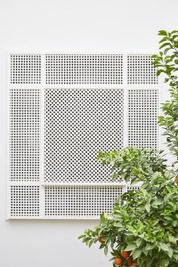 une fenêtre avec une grille blanche derrière une plante dans l'établissement Numa Marrakech, à Marrakech