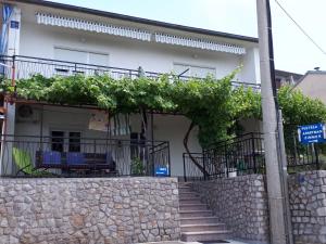 une maison dotée d'un balcon avec des chaises bleues. dans l'établissement Apartment Ana Skale, à Senj