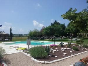 una piscina en un patio con jardines en Agriturismo Dolce Verde, en Castiglione del Lago