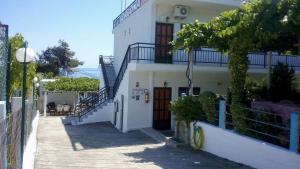 a white building with stairs on the side of it at Gorgona Rooms in Alyki