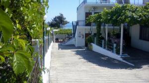 a wooden walkway in front of a white building at Gorgona Rooms in Alyki