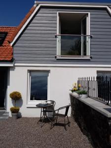 a white house with a table and a window at The Smithy in Largoward