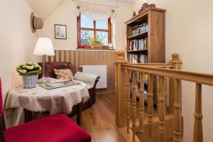 a living room with a table and a book shelf at Dom Na Rozdrozu in Krokowa