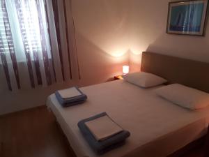 1 dormitorio con 1 cama con 2 almohadas en Apartments Aria, en Stari Grad