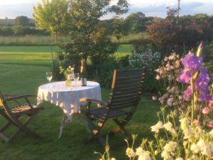 a table with two chairs in a yard with flowers at Eydon B&B in Daventry