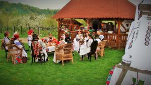 a group of people sitting at a table in a gazebo at Pensiunea Rares in Bistriţa Bîrgăului
