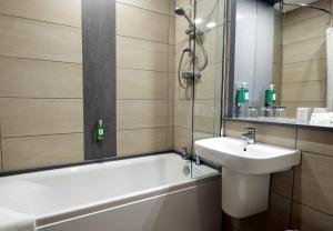 a bathroom with a tub, sink and mirror at Pitbauchlie House Hotel - Sure Hotel Collection by Best Western in Dunfermline