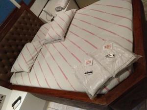 a bed with a white and red striped pillow at Hotel Flor da Vila Mariana in Sao Paulo
