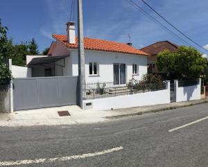 a white house with a fence on the side of the street at Casinha da Vila in Arcos de Valdevez