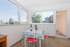 a dining room with a table and chairs and windows at Haus Valerija in Labin +17 photos
