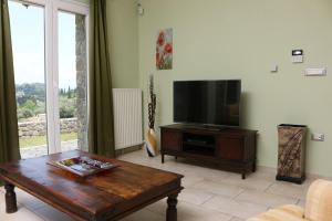 a living room with a television and a coffee table at Corfu View Deluxe in Perama