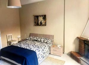 een slaapkamer met een blauw en wit bed en een open haard bij Da zio Totò in Scilla